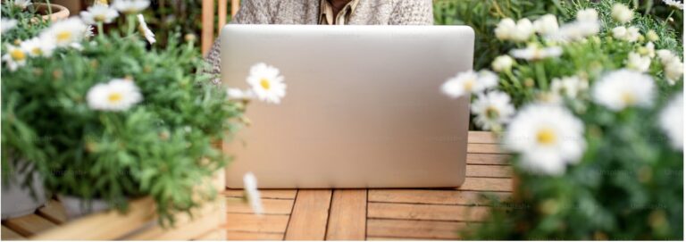 Psychothérapie en ligne en français et en espagnol Photo d'un ordinateur au milieu de fleurs représentant le bien être que peut procurer la psychothérapie avec un psychologue bilingue français-espagnol