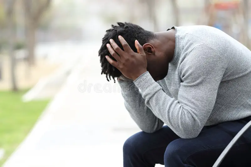 Psychothérapie en ligne en français et en espagnol homme de couleur deprime triste sur un banc dans le parc portrait vue cote d noir assis 177762638
